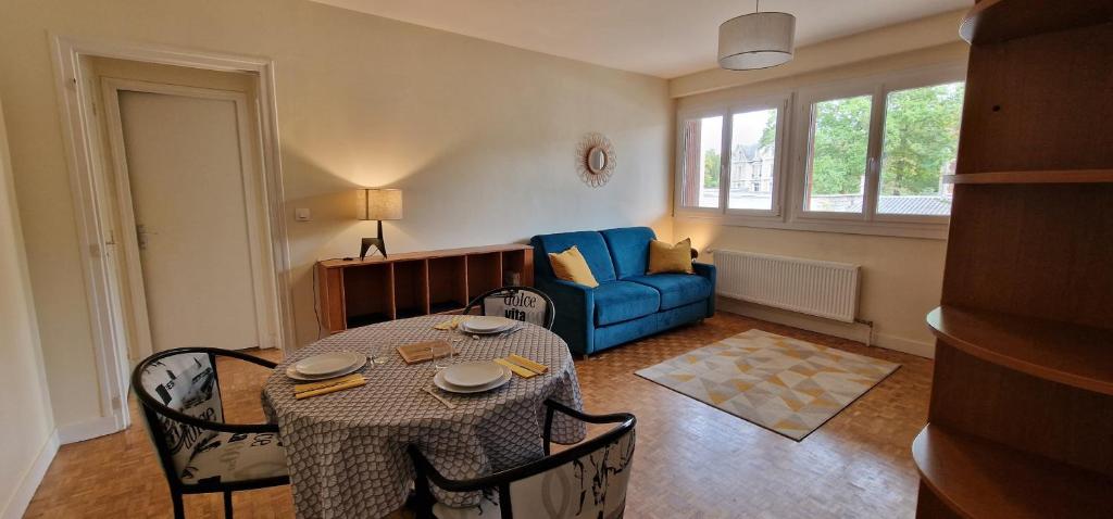 尚蒂伊Le Sleipnir - Appartement cantilien calme (proche gare SNCF)的客厅配有桌子和蓝色沙发