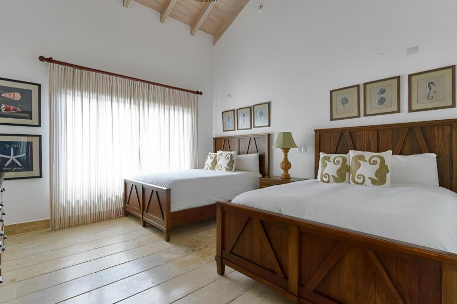璜多里奥Majestuosa villa en Juan Dolio, Guavaberry Golf & Country Club的一间卧室设有两张床和窗户。