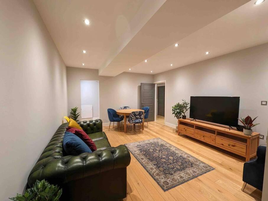布伦特伍德Elegant Central Brentwood Flat的客厅配有真皮沙发和电视