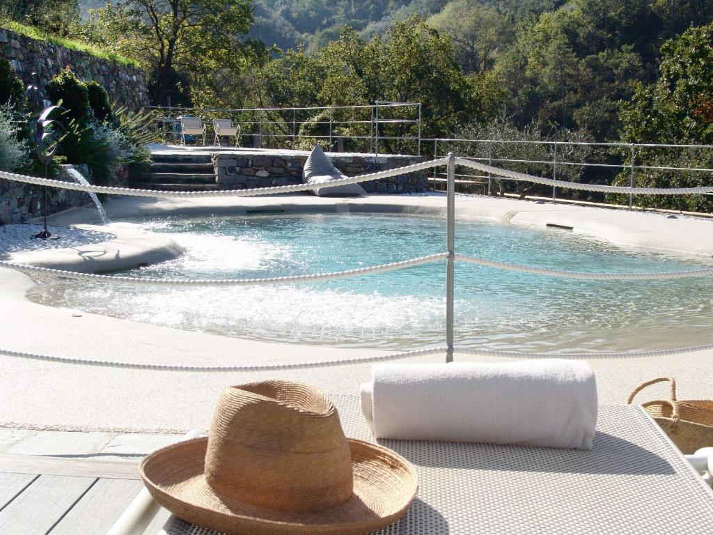 莱万托Villanova - Nature & Wellness的坐在游泳池旁桌子上的帽子