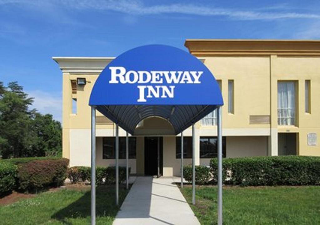 坎普泉Rodeway Inn Joint Base Andrews Area的建筑前的蓝色道路标志旅馆