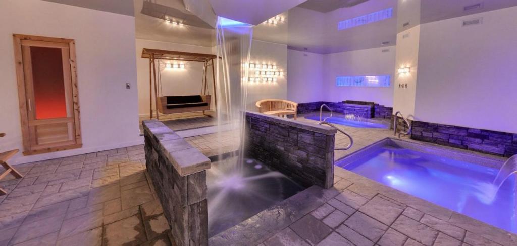拜圣保罗Hôtel-Auberge la Grande Maison et Spa的大型浴室设有一座带热水浴缸的游泳池