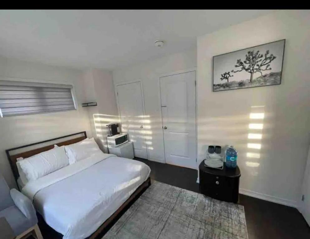 米西索加Ensuite guest room with separate entrance的卧室配有白色的床和地毯。