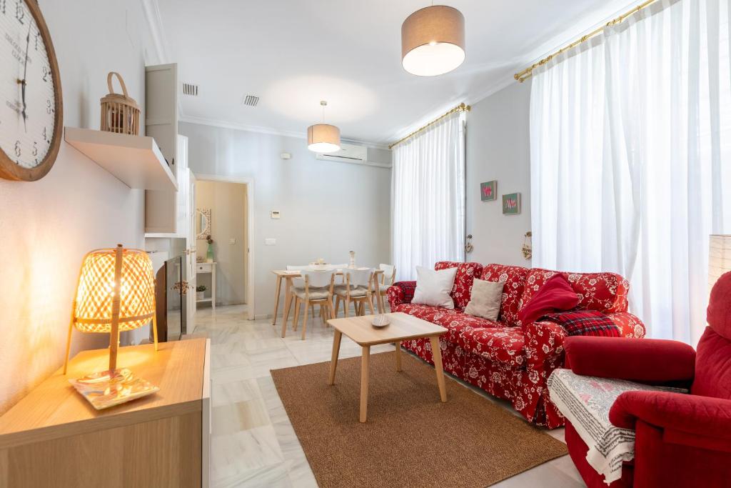 塞维利亚San Lorenzo en Esencia的客厅配有红色的沙发和桌子