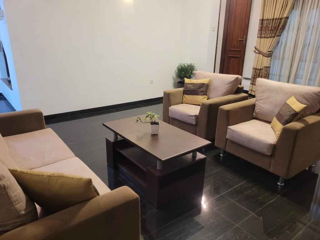 斯里贾亚瓦德纳普拉科特M-stay Colombo的带沙发和咖啡桌的客厅