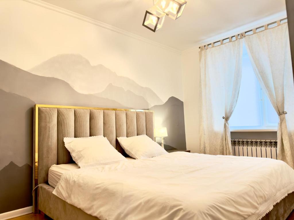 阿特劳Двушка около Академии Scandinavian Style的卧室配有一张大床,墙上挂有山壁画