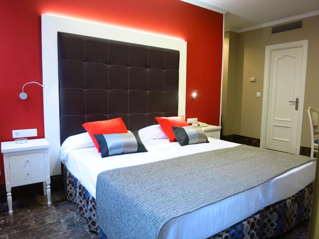巴利亚多利德精品大教堂酒店的一间卧室配有一张大床和大床头板