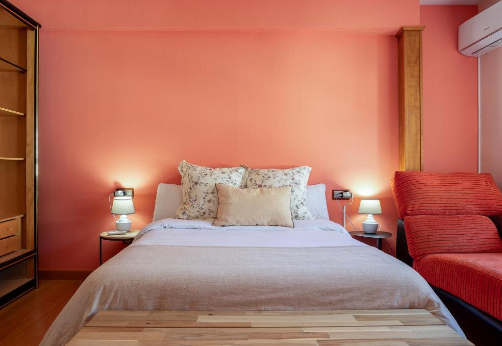 托尔纳瓦卡斯APARTAMENTO TURÍSTICO ABUELO TEÓFILO的一间卧室设有一张床和红色的墙壁