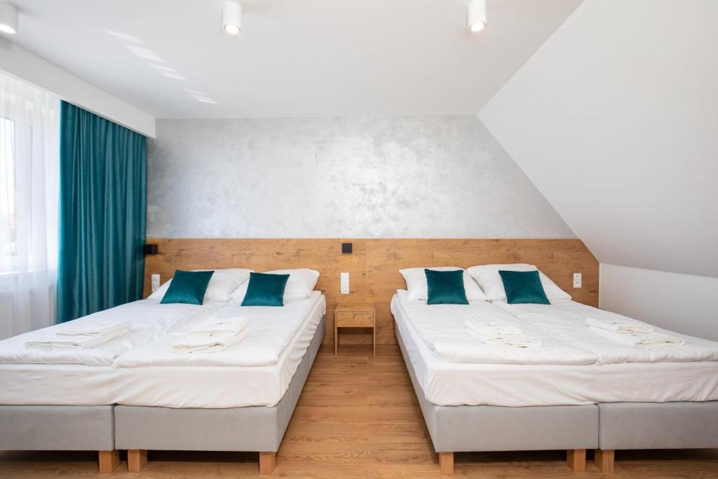 KoninaGorczański Zakątek的配有蓝色枕头的客房内的两张床