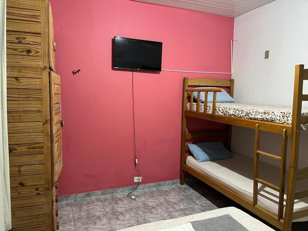 马瑙斯Luso Apartamentos的客房设有两张双层床和墙上的电视