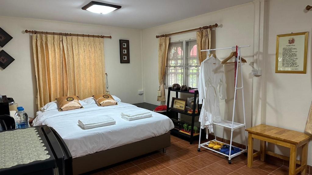 Ban Nong Chum SaengNarai - Homestay in Thapthan (B)的一间卧室配有一张床和衣架