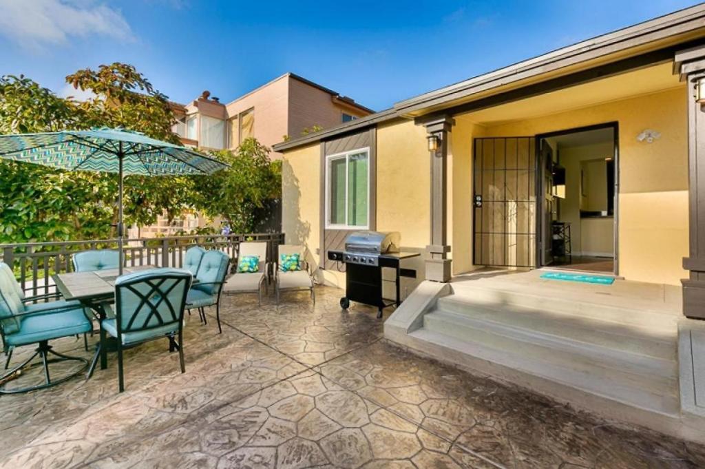 圣地亚哥Riviera Bay View Dream - Private patio with bay view and parking的庭院配有桌椅和遮阳伞。