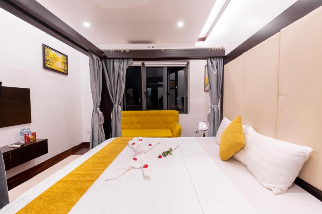 河内Hanoi Cozy Legend Hotel的一间卧室配有一张白色大床和黄色沙发