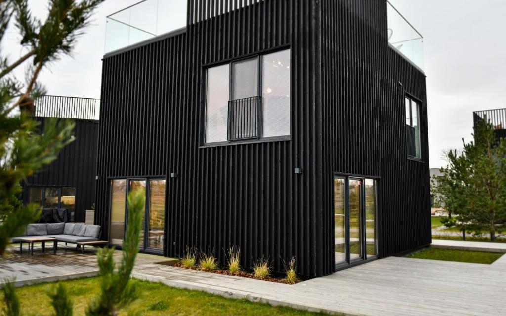 SvencelėNamo nuoma Svencelėje的一间黑色房子,设有大窗户