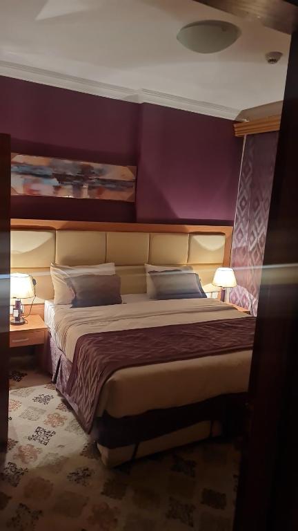 麦加شقق فندقية التلال的一间卧室设有一张紫色墙壁的大床