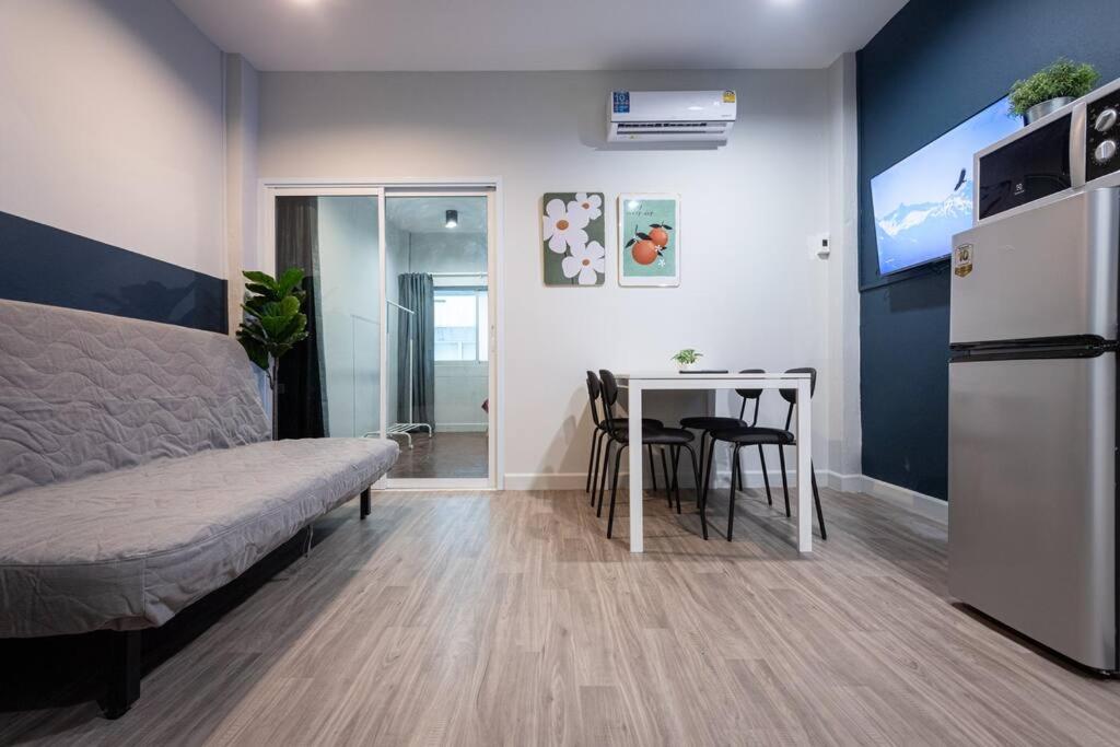 曼谷A2 Comfortable space wt Kitchen的客房设有床、桌子和冰箱。