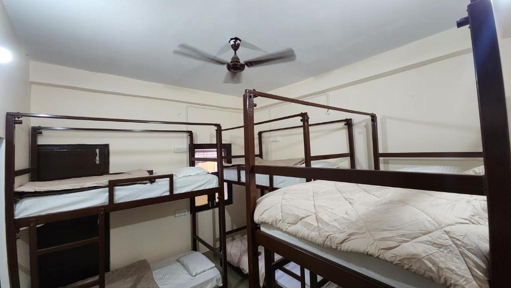 瓦拉纳西Banaras Gully House 500 ft from The Ghats的客房设有三张双层床和吊扇。