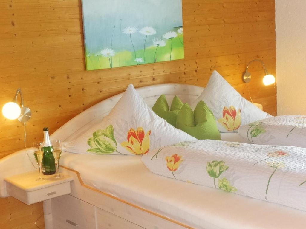 Böbrach艾玛兰德豪斯酒店的一间卧室配有两张带白色床单和鲜花的床。
