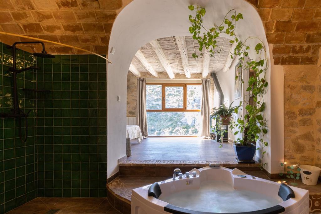 PatróCasa rural Vall de Gallinera con Chimenea, piscina y jacuzzi DIANIA的带浴缸的浴室和绿色瓷砖地板。