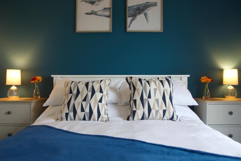 奥克尼Peedie Picky Townhoose - STL OR00094F的一间卧室配有一张蓝色墙壁的床和两盏灯。