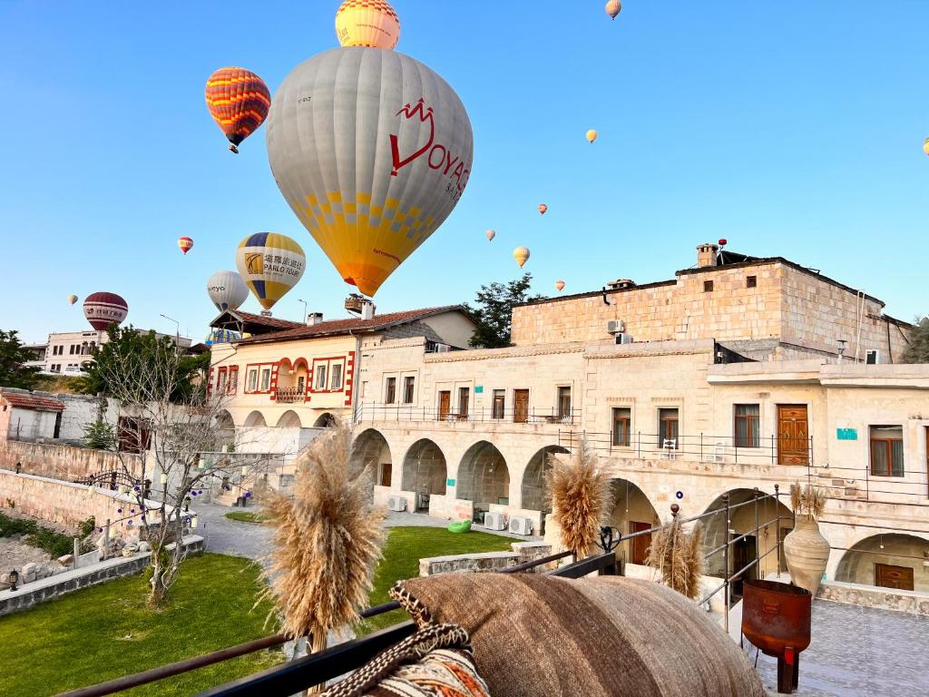 格雷梅Jacob's Cave Suites - Cappadocia的一组热气球飞越一座建筑物