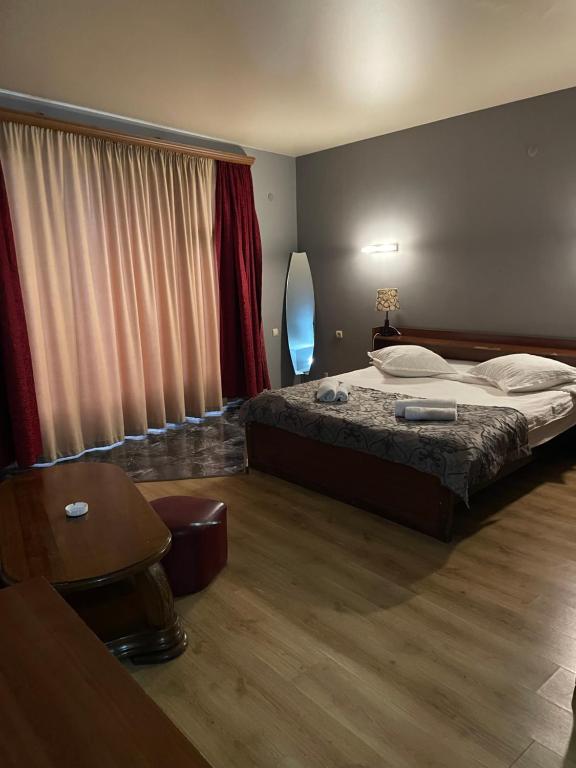 第比利斯Hotel ERA的卧室配有1张床、1张桌子和1把椅子