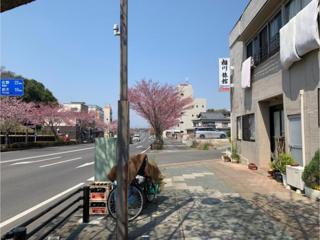 小山市Aikawa Ryokan - Vacation STAY 04180v的一条狗坐在街上的自行车上