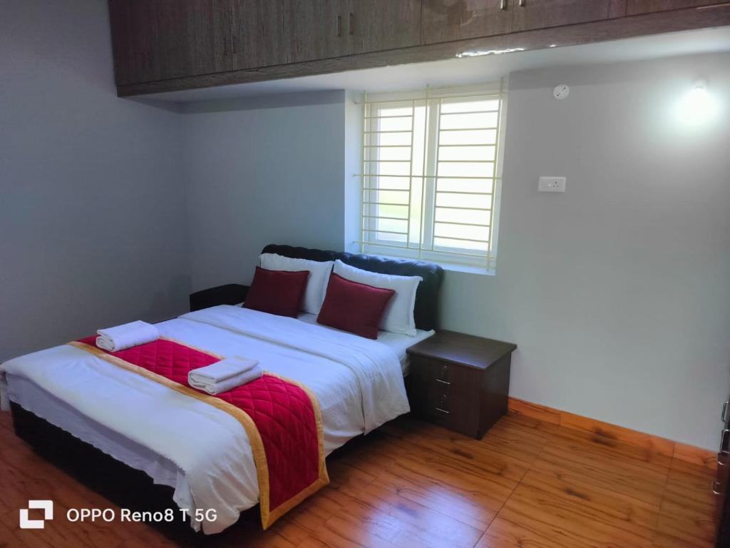 埃尔加德JK Resort的一间卧室配有带白色床单和红色枕头的床。