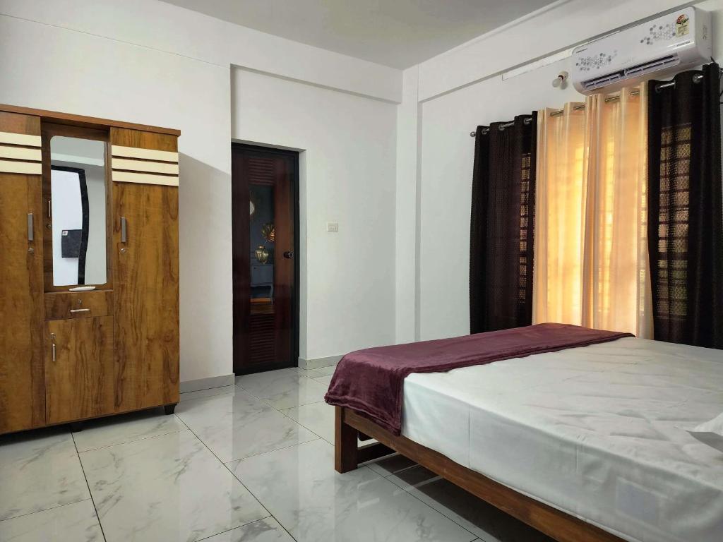 特里凡得琅GOPURAM的一间卧室配有一张床和一扇木门