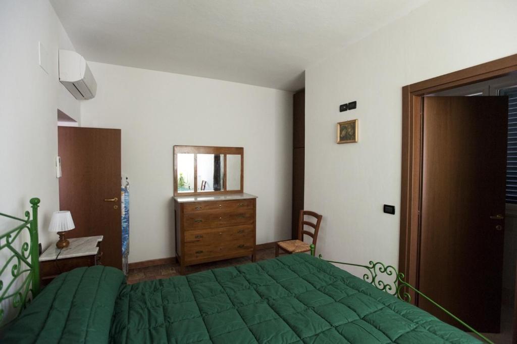 ColledaraGran sasso white的一间卧室配有绿色的床和木制梳妆台