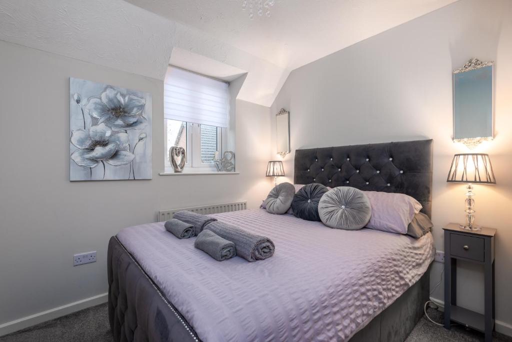 伍斯特WORCESTER Fabulous Cherry Tree Mews self check in dogs welcome by prior arrangement , 2 double bedrooms ,super fast Wi-Fi, with free off road parking for 2 vehicles near Royal Hospital and woodland walks的一间卧室配有一张大床和枕头