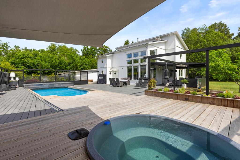 斯德哥尔摩Exclusive villa Stockholm的一个带游泳池和房子的后院
