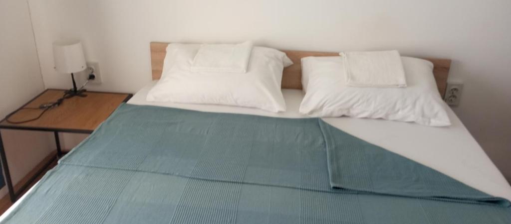 贝尔格莱德Airport MD rooms的一张带两个白色枕头和桌子的床