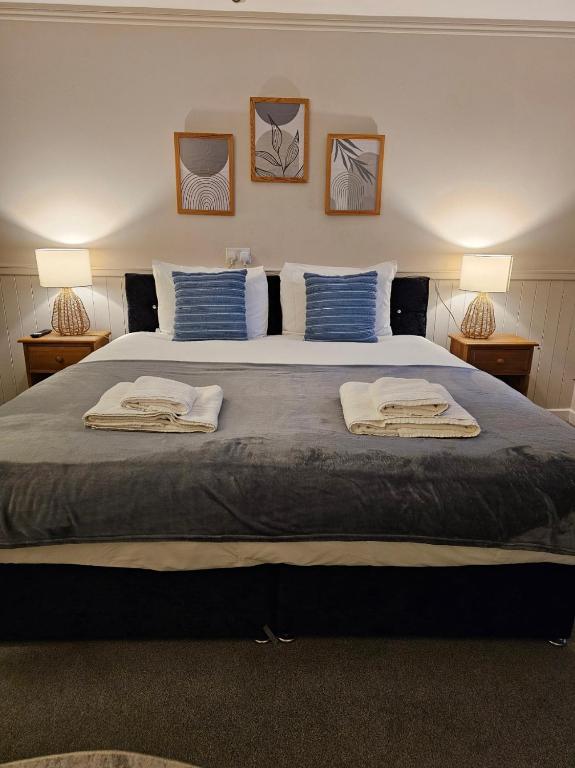卡恩Dog and Partridge Inn的一间卧室配有一张大床和两条毛巾