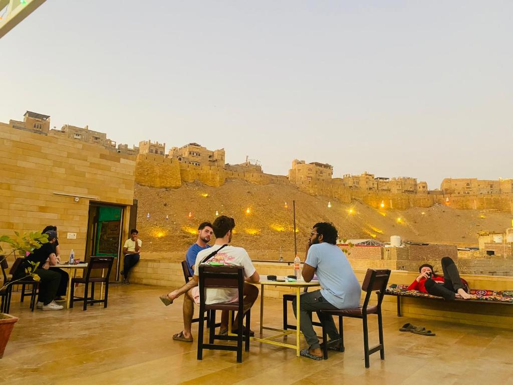 斋沙默尔Wonbin Safari Jaisalmer的一群坐在城堡前桌旁的人