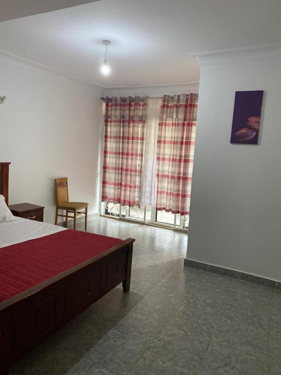 NamugongoIngrid's Place - Namugongo的一间卧室配有床和两个带窗帘的窗户