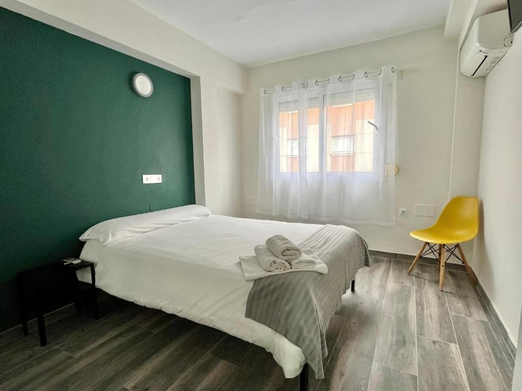 多列毛利诺斯New Click & Room的一间卧室配有一张床和一张黄色椅子