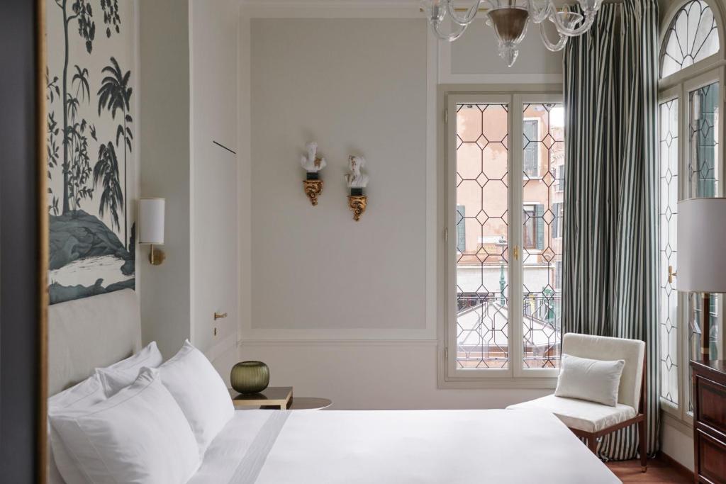 威尼斯Violino d'Oro Venezia的一间卧室配有一张床、一把椅子和窗户。