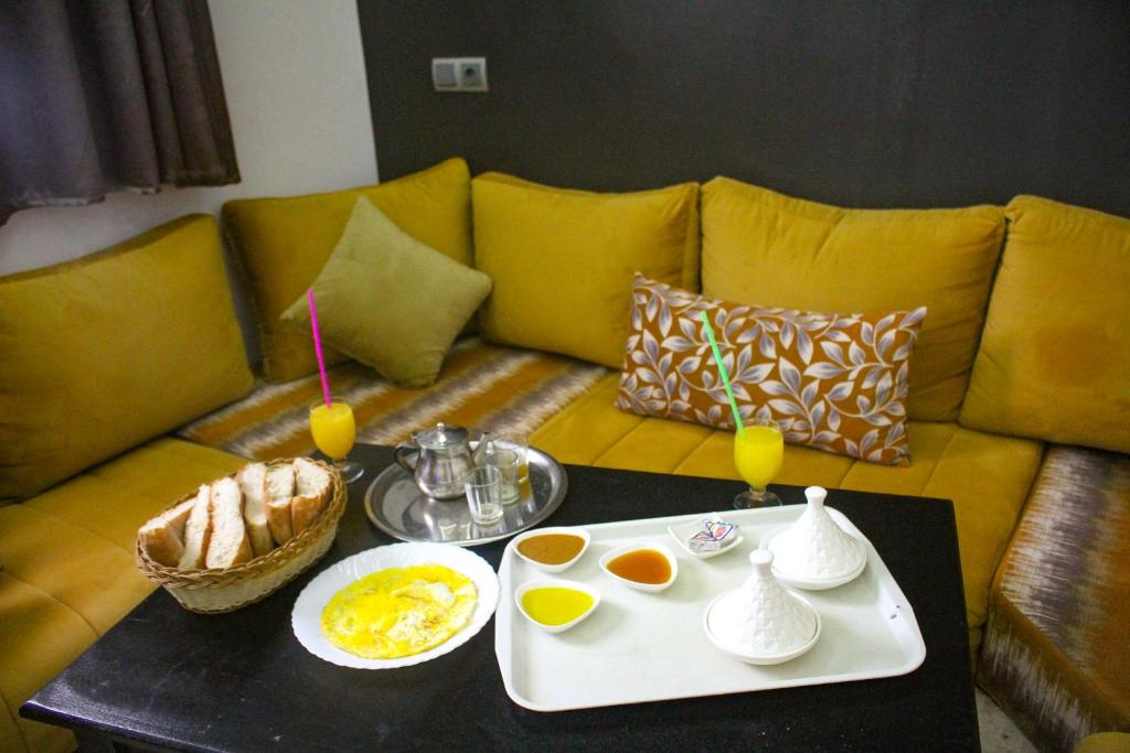 Tan-Tan Plage春分露营地旅馆的一张带桌子的沙发,包括鸡蛋和饮料