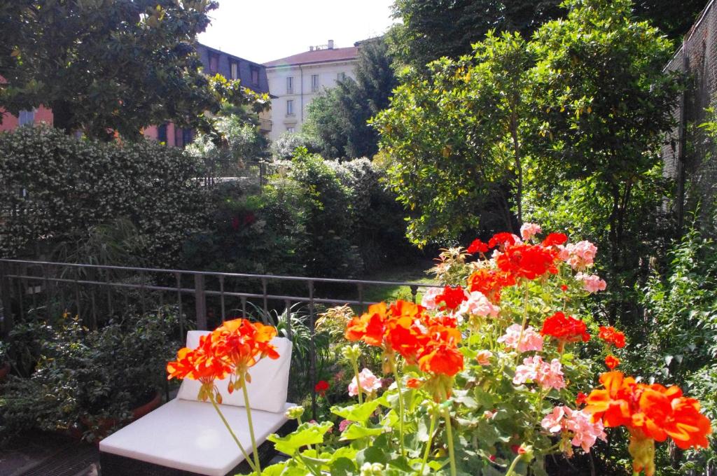 米兰特奥多拉住宿加早餐旅馆的花园里的长凳,种着红色的花