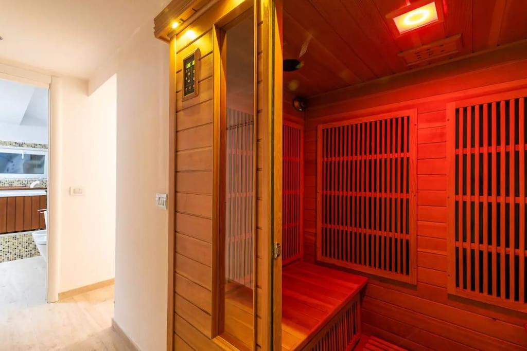 米兰[Moscova - Garibaldi] Lusso, Sauna e Idromassaggio的一间设有红色墙壁和红色长凳的桑拿浴室