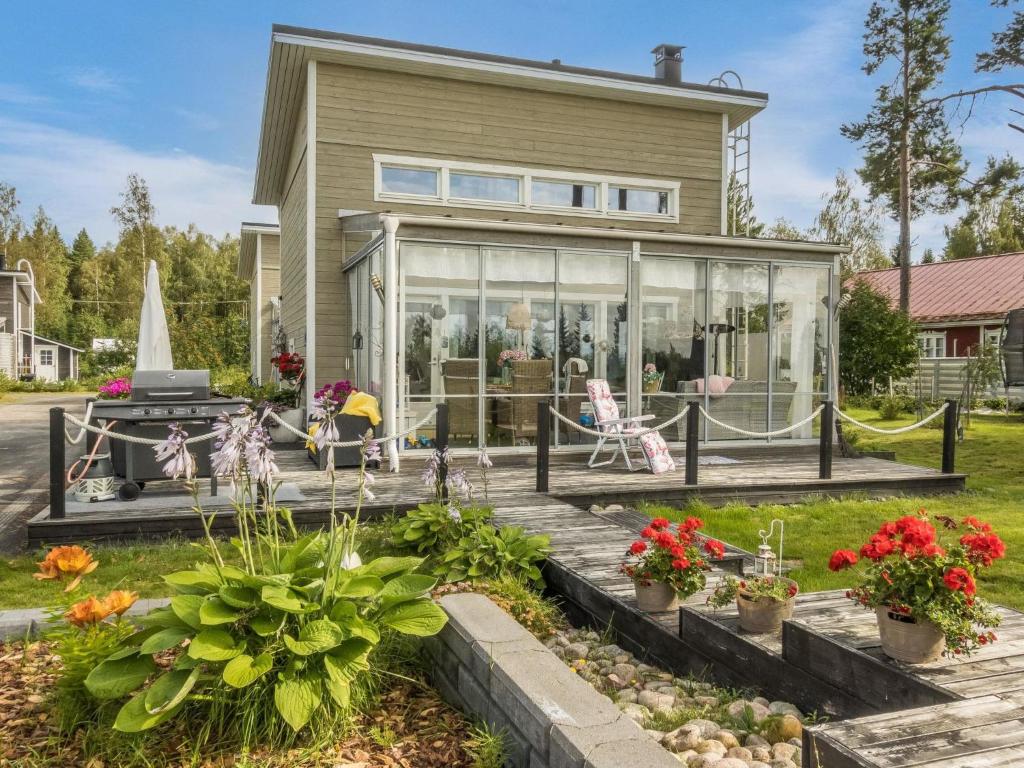 OulunsaloHoliday Home Peuhu a4 by Interhome的院子里有玻璃门和鲜花的房子