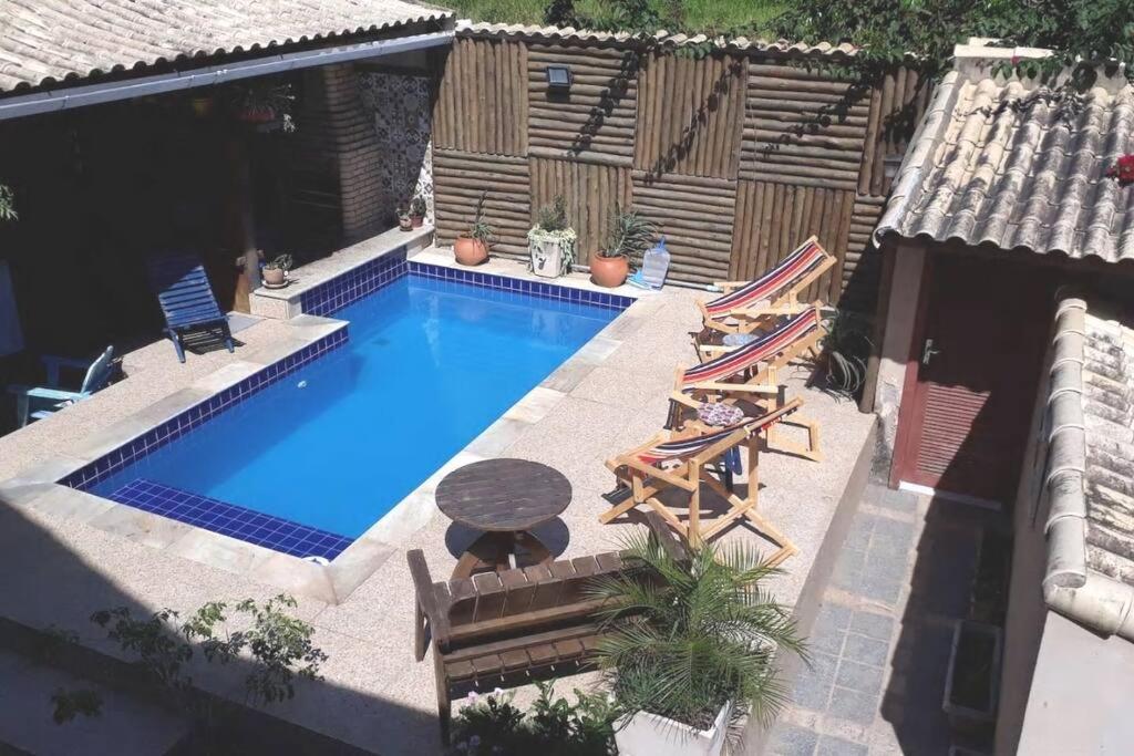 布希奥斯Casa completa + área gourmet的享有带椅子和桌子的游泳池的顶部景致