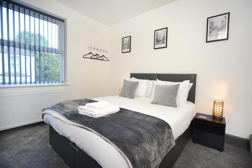 南安普敦Executive 8 Beds 2 Bath Home Contractors Parking的一间卧室配有一张带白色床单的床和一扇窗户。