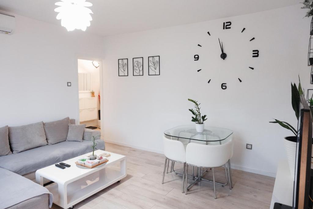 奥西耶克Apartman Franko - SELF CHECK IN的客厅配有沙发和墙上的时钟
