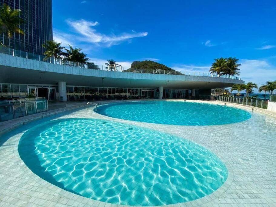 里约热内卢Quarto no Hotel Nacional com vista mar para a Praia de São Conrado, RJ的大楼前的大型游泳池