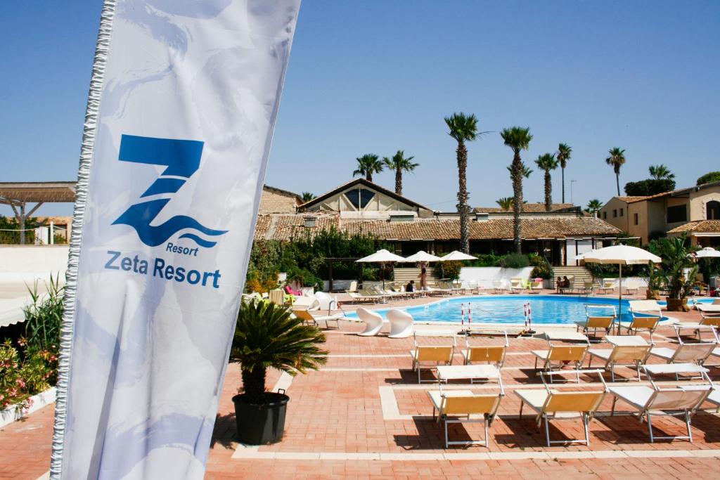 希克利Zeta Resort Donnalucata的一个带椅子和游泳池的迷人度假胜地的标志