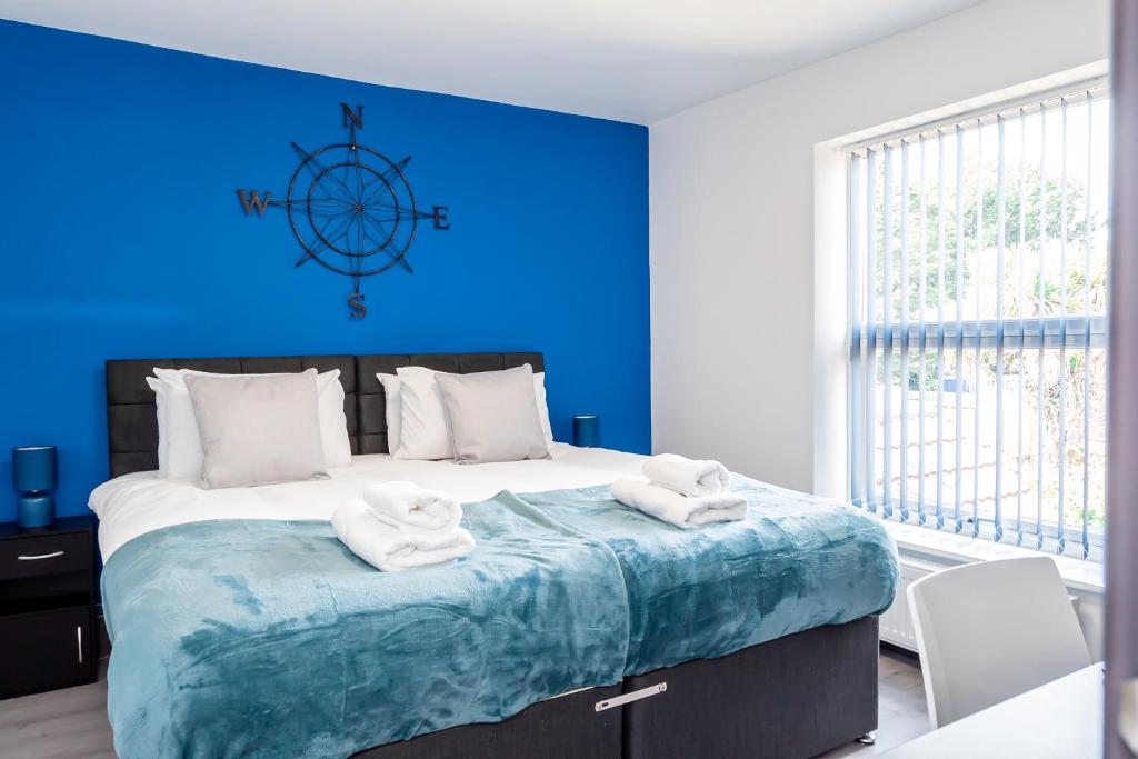 南安普敦Executive 8beds 3bath Contractors Welcome Parking的蓝色卧室配有一张大床和毛巾