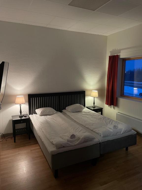 维纳什堡Trestads Värdshus的一间卧室配有一张大床,桌子上放着两盏灯
