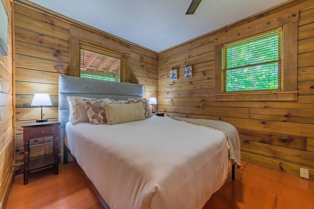 鸽子谷Couples Getaway Cabin near National Park w Hot Tub的一间带木墙的卧室和一张位于客房内的床